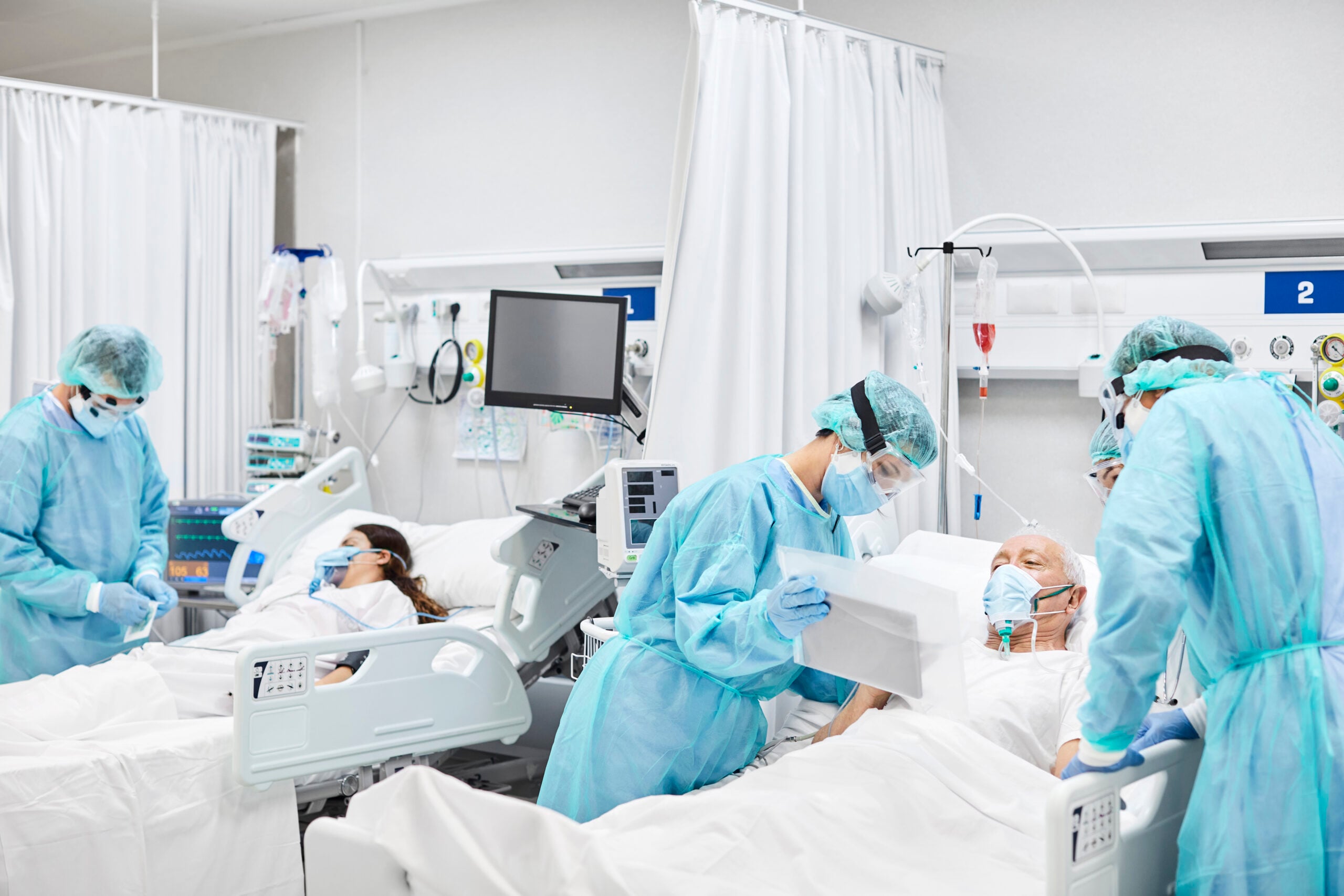 Doctors and nurses taking care of patients in ICU
